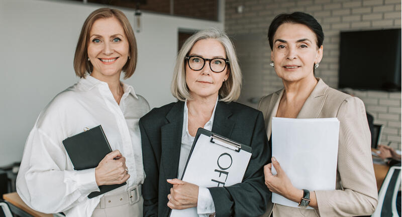 Women smiling around a table at a work meeting